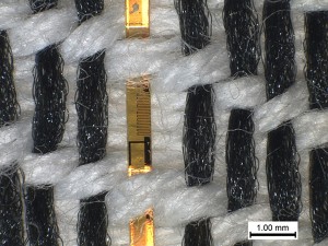 Smarte Textilien unter der Lupe: Zu erkennen sind die eingewobenen Plastikfäden, in welche Temperatursensoren integriert sind (Bild: K. Cherenack / ETH Zürich)